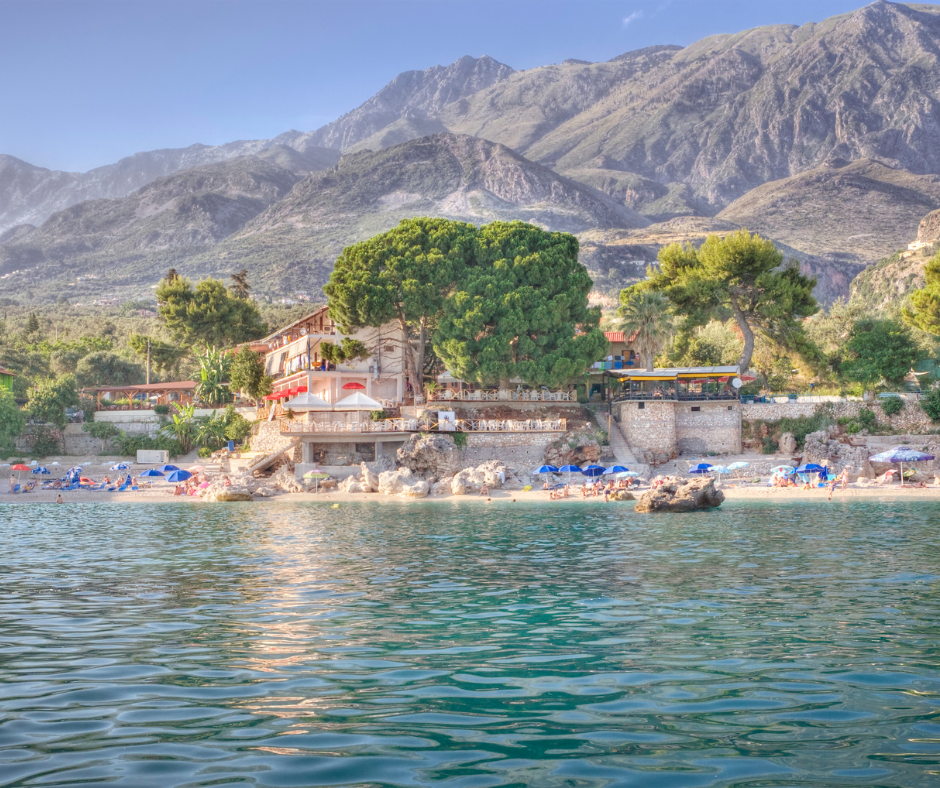 a view of the beach and mountains from a boat a view of the beach and mountains from a boat