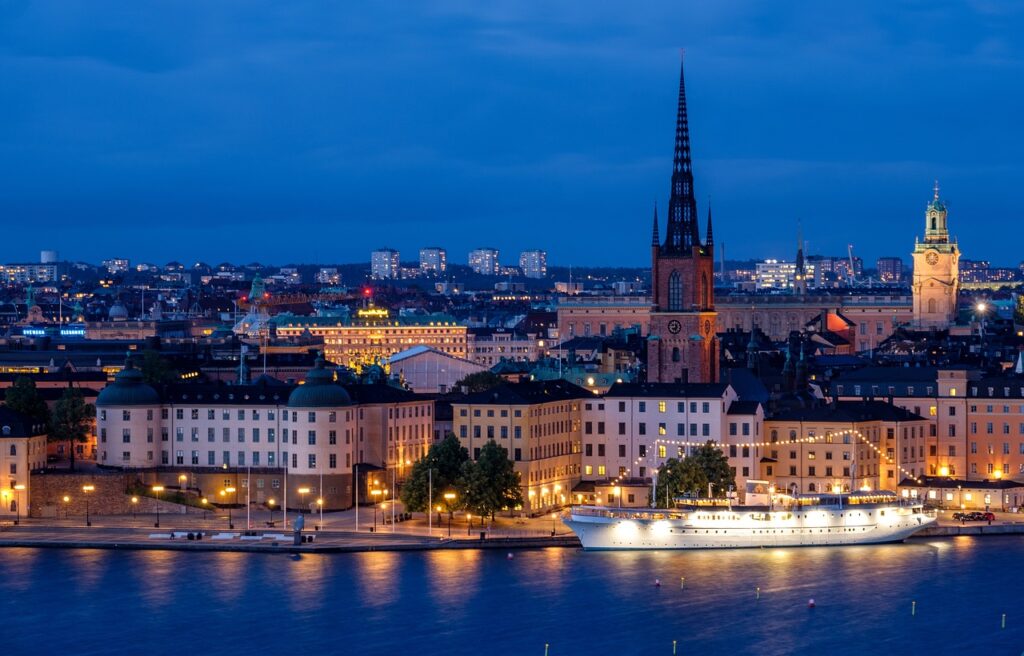 Sweden city, cityscape, waterfront, illuminated, ship, architecture, skyline, historic center, church, steeple, water, nature, sea, night, evening, twilight, lights, mirroring, stockholm, sweden, scandinavia
